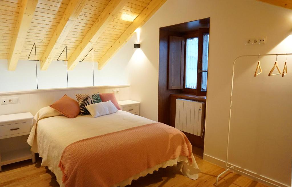 a bedroom with a bed with an orange blanket at Apartamentos Turísticos El Peñón in Tapia de Casariego