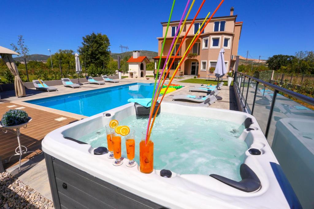 - un bain à remous avec des cocktails orange à côté de la piscine dans l'établissement Villa Maris, à Dugopolje