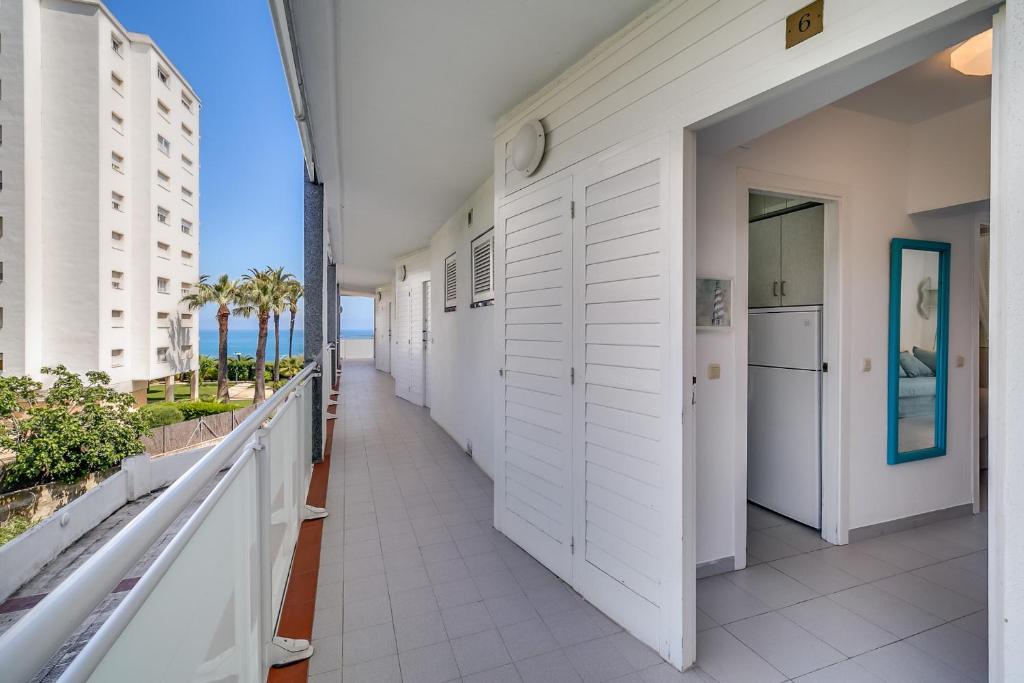 un couloir avec des portes blanches et un balcon donnant sur l'océan. dans l'établissement Hauzify I Apartaments Sot del Morer, à San Pol de Mar