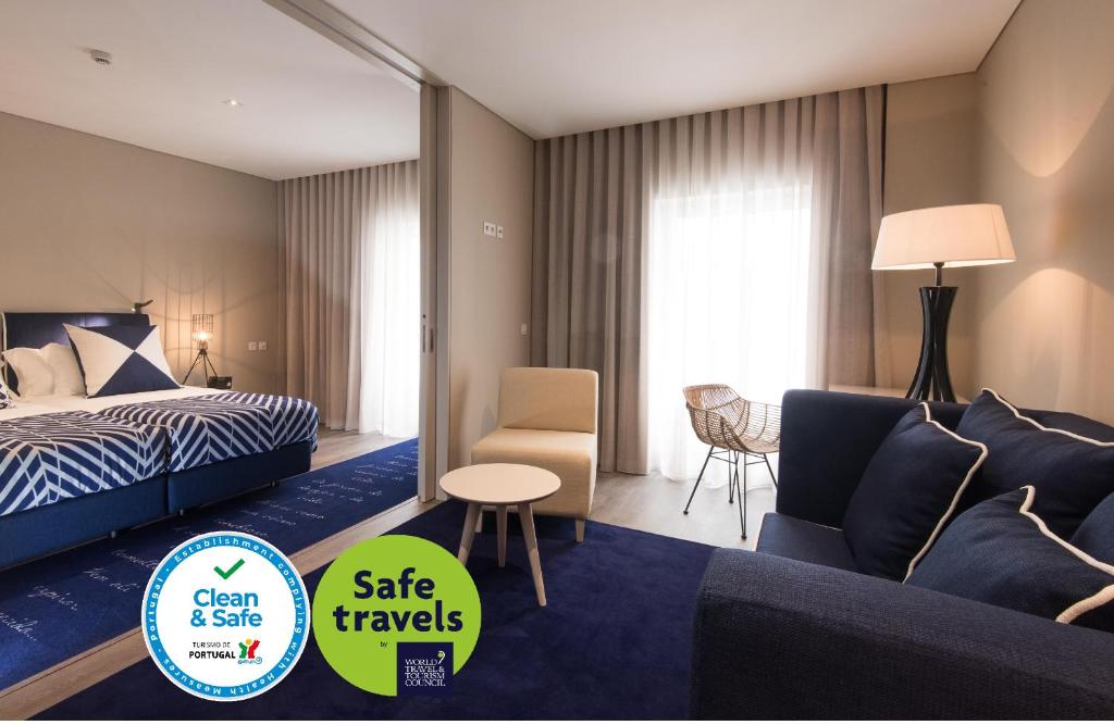 ein Hotelzimmer mit einem Bett, einem Sofa und einem Stuhl in der Unterkunft Hotel Casa Hintze Ribeiro in Ponta Delgada
