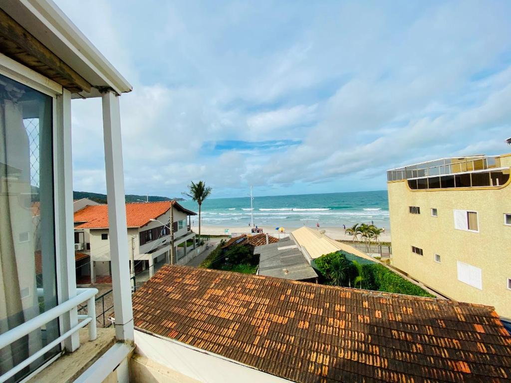 a view of the beach from the balcony of a house at Ilha de Rhodes in Bombinhas