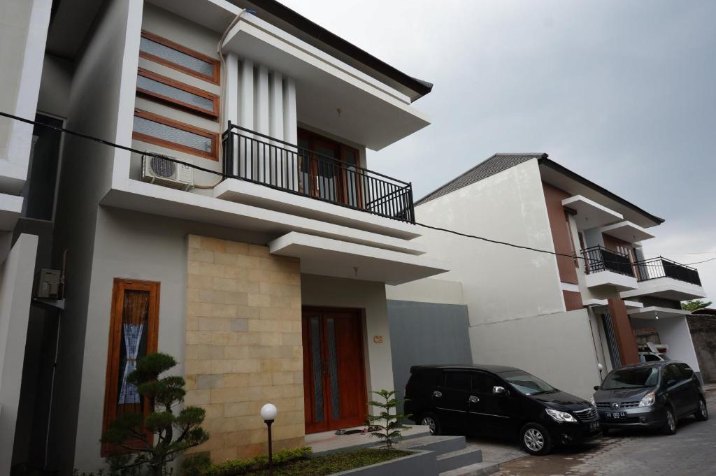 twee auto's geparkeerd voor een huis bij Cemara Homestay Jogja in Yogyakarta