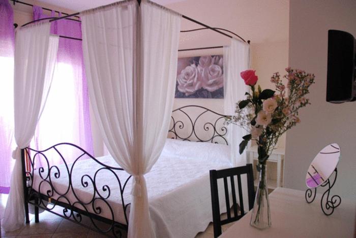 ローマにあるStefy's Roomsの花瓶付きの天蓋付きベッドが備わるベッドルーム1室