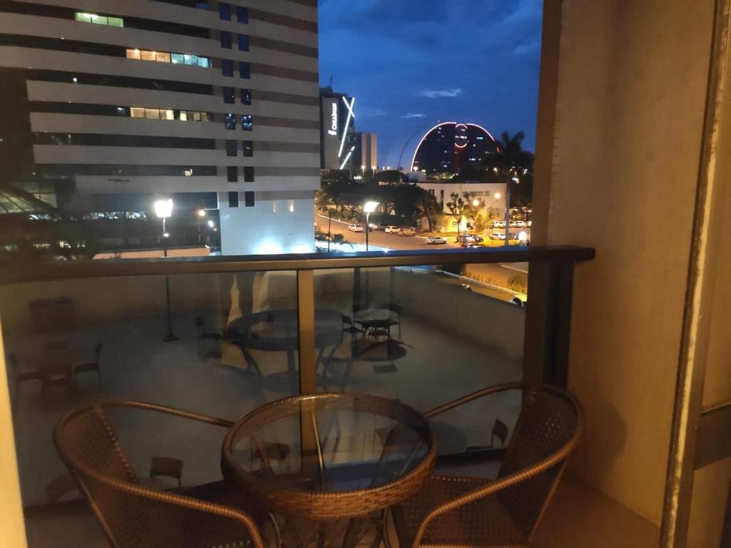 a balcony with chairs and a table with a view of a city at Flat Plaza Hotel - Setor de Hotéis Norte in Brasília