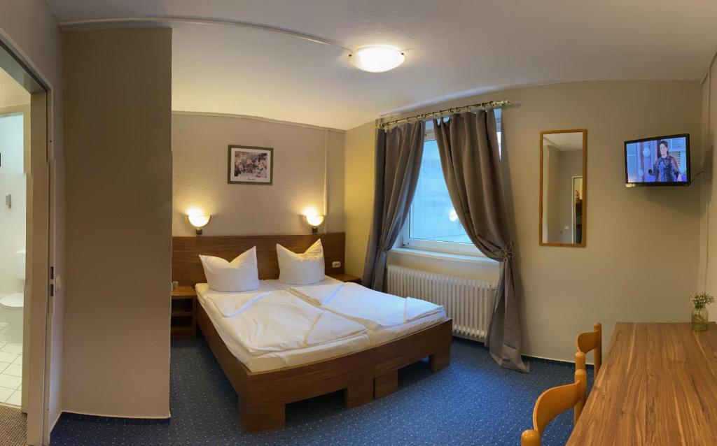 um quarto de hotel com uma cama e uma janela em City Hotel Ansbach am KaDeWe em Berlim