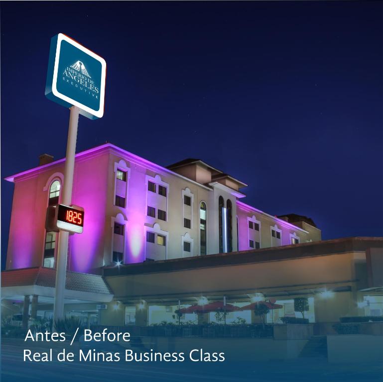 un edificio rosa con un cartel delante en Imperio de Angeles Executive León by Real de Minas Business Class, en León