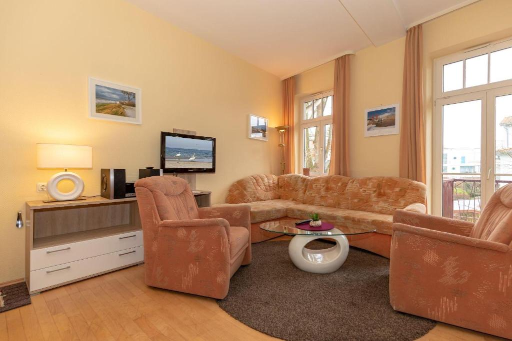 キュールングスボルンにあるResidenz-Ostseewind-Wohnung-16-280のリビングルーム(ソファ、椅子、テレビ付)