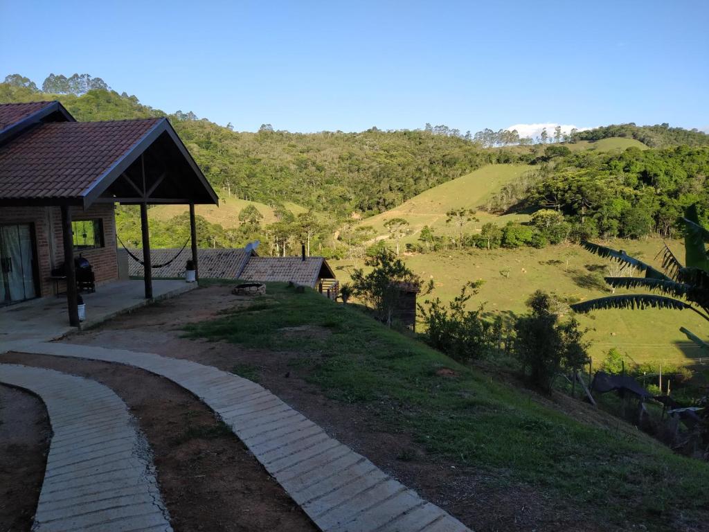 a brick path leading to a house with a hill at Rancho dos Mantas in Santo Antônio do Pinhal