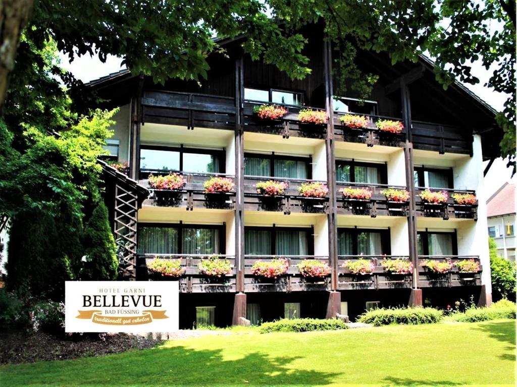 バート・フュッシンクにあるHotel garni Bellevueのバルコニーに花箱が設置された大きな建物