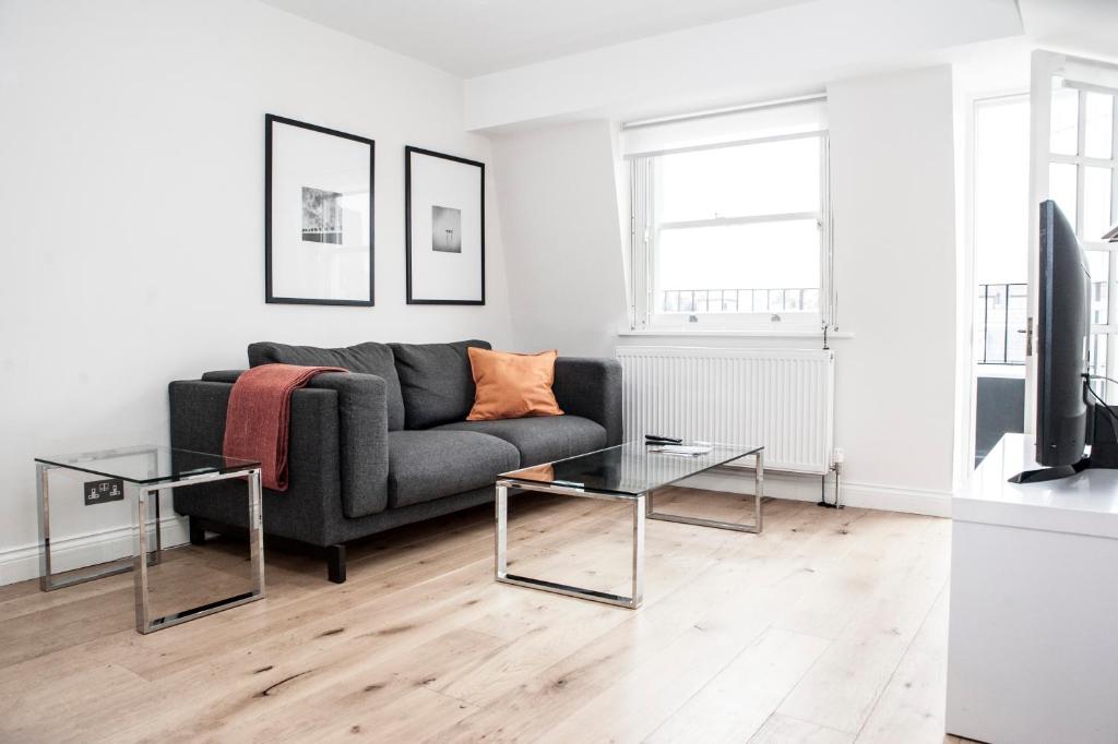 ein Wohnzimmer mit einem Sofa und 2 Tischen in der Unterkunft UNIQUE 2bed/2bath - TOP FLOOR - Private Balcony in London