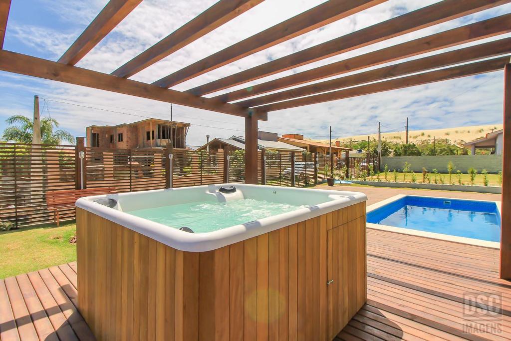 a hot tub on a deck next to a pool at Dunas Studios in Garopaba