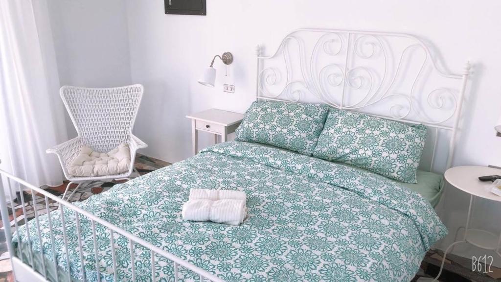 1 dormitorio con 1 cama con manta verde y silla en 莉莉的家 Lilys - 高雄橋頭老街民宿 