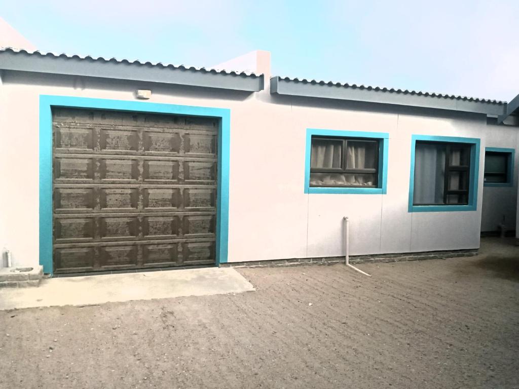 a house with two garage doors and a window at LILIAN Self Catering Accommodation in Swakopmund