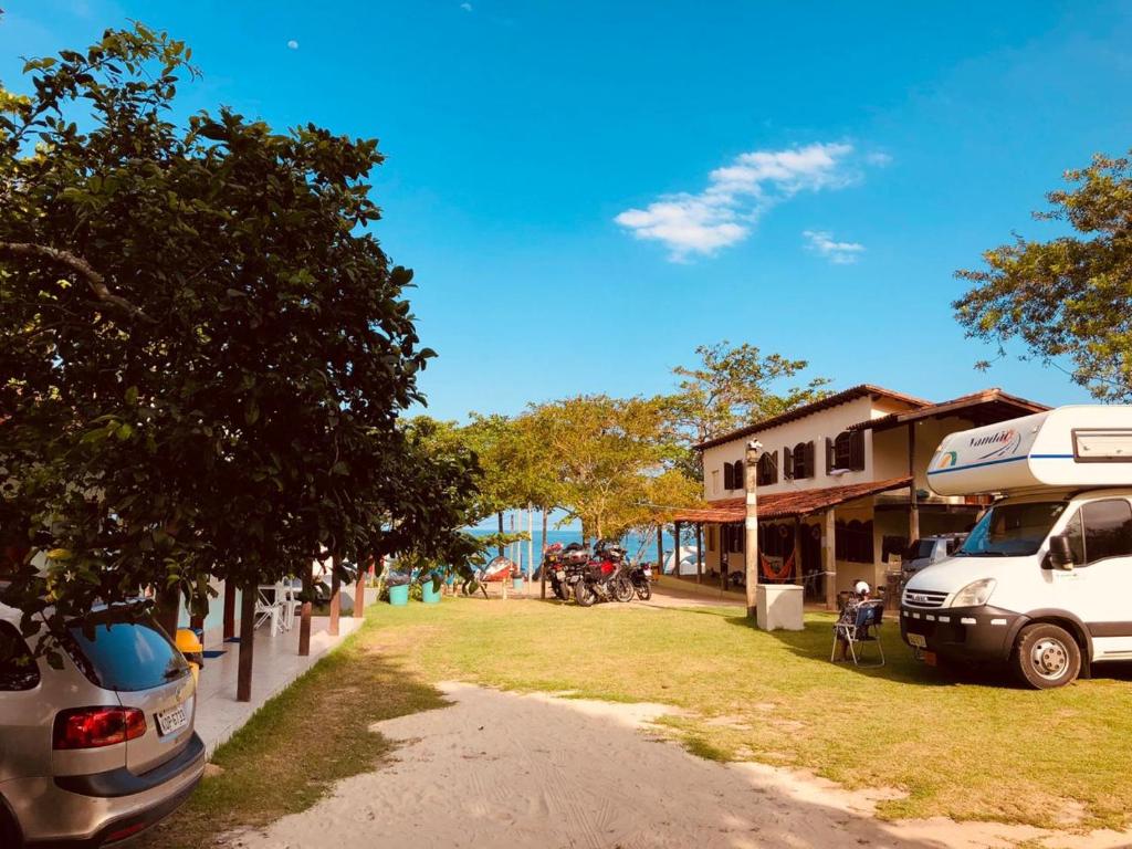 a rv parked in front of a house with a yard at Suite rustica in Paraty