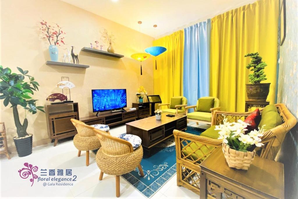 ein Wohnzimmer mit einem Sofa, Stühlen und einem TV in der Unterkunft Floral Elegance2 @ Galacity in Kuching