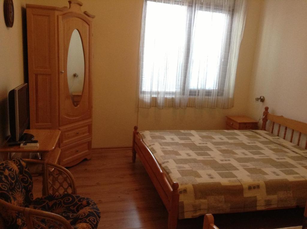 1 dormitorio con 1 cama, vestidor y ventana en Guest Rooms Toni & Miro, en Tryavna