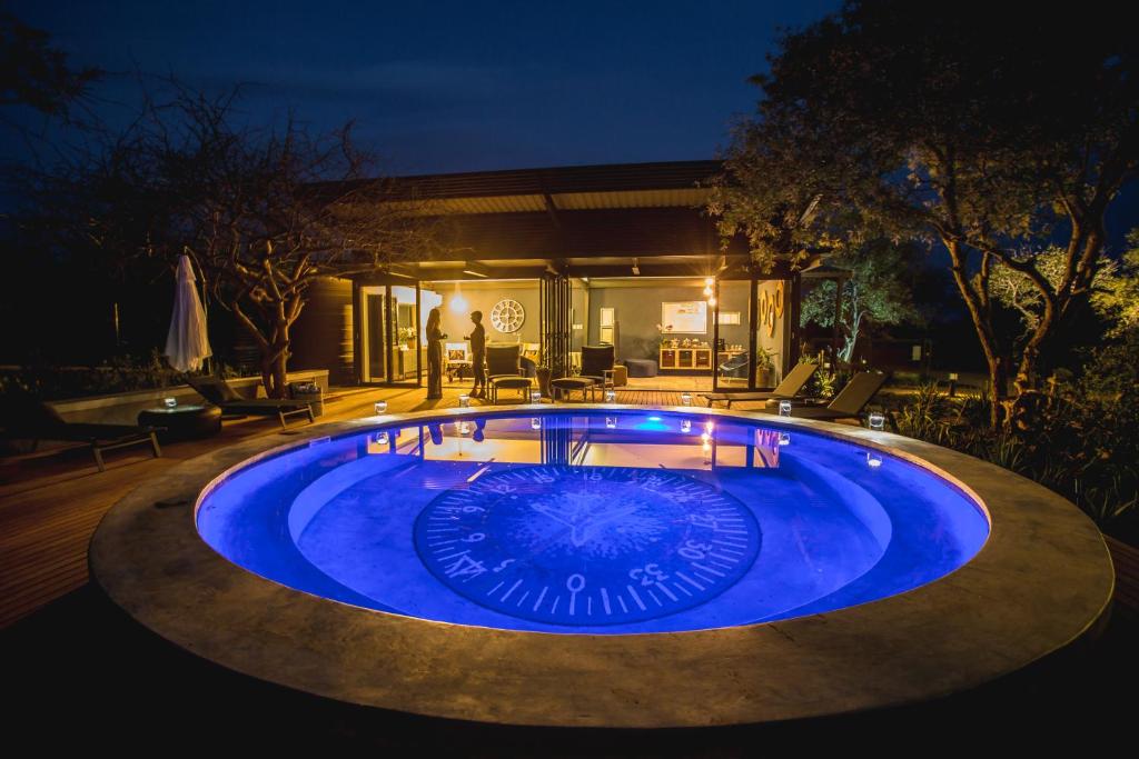 a swimming pool in a backyard at night at Aerotel in Hoedspruit