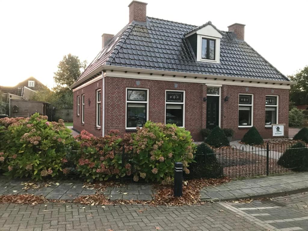 a red brick house with a black roof at B&B Oldemarkt in Oldemarkt