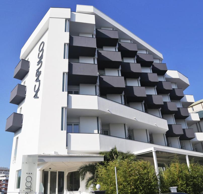 a white building with black balconies on it at Acapulco Hotel in Cattolica