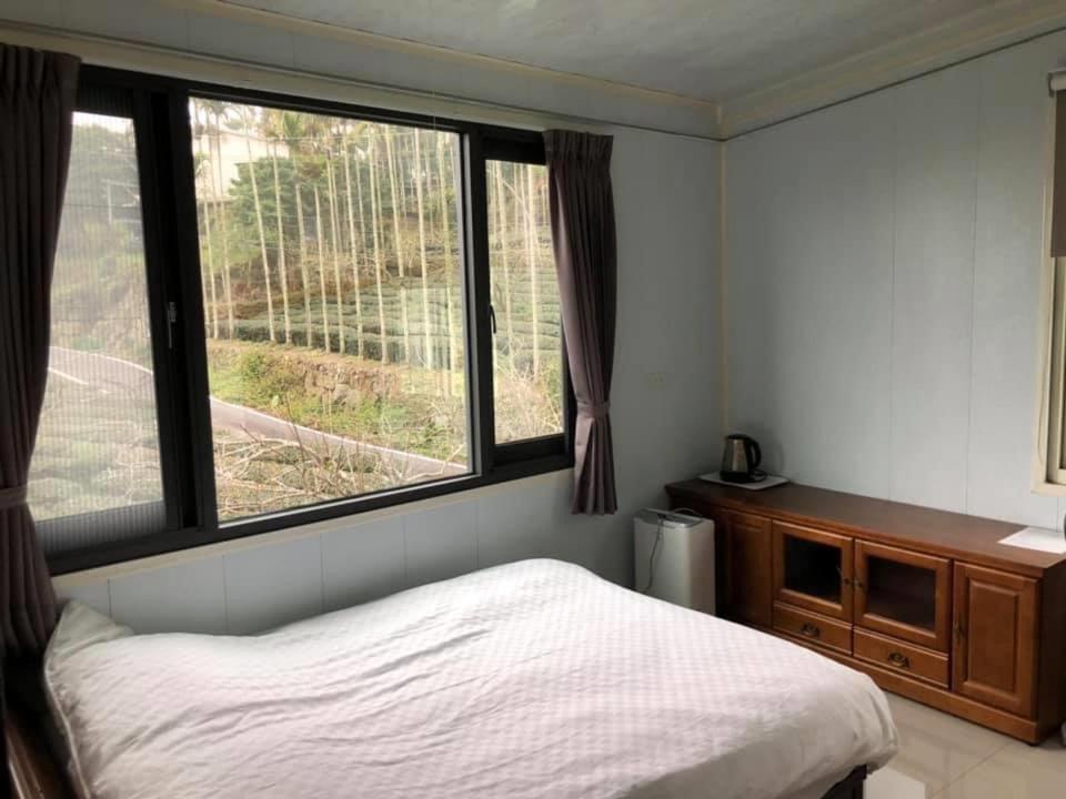 a bedroom with a bed and a large window at Bao Chi B&B in Fanlu