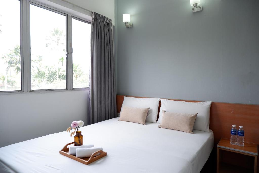 sypialnia z białym łóżkiem i oknem w obiekcie Indah Garden Hotel w mieście Ampang Resettlement