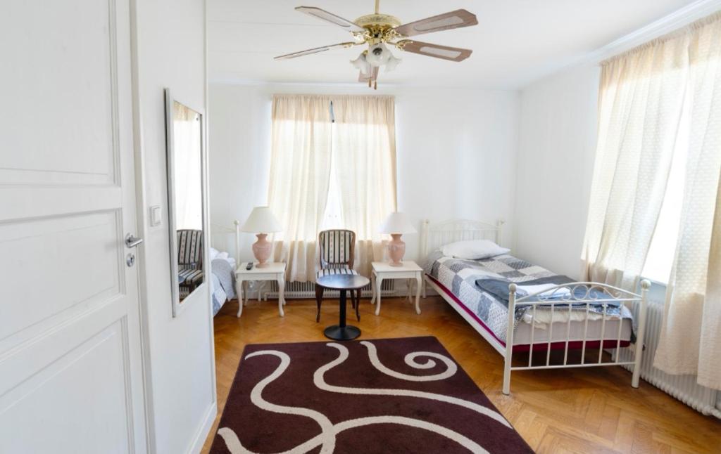 a bedroom with a bed and a ceiling fan at Motala Wärdshus in Motala