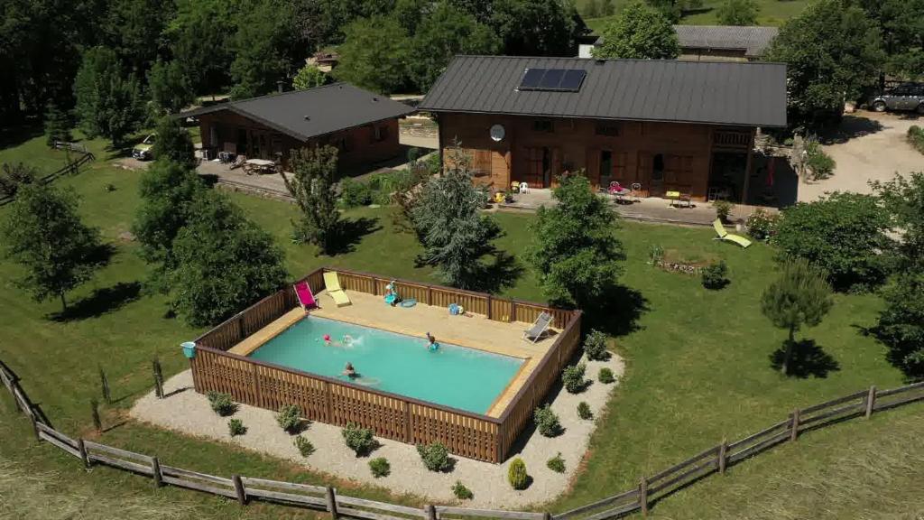 an overhead view of a swimming pool in a yard next to a house at Gîte des Conquettes in Salles-la-Source