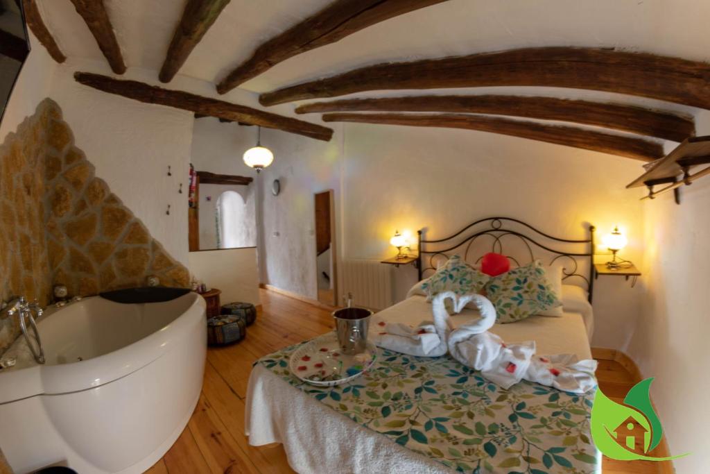 1 dormitorio con bañera, cama y bañera en Cazorla Rural, en Quesada