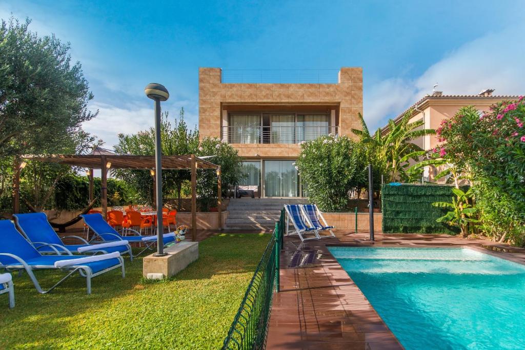 a backyard with a swimming pool and chairs and a house at 206 Villa Isabel ET2341 by Mallorca Charme in Alcudia