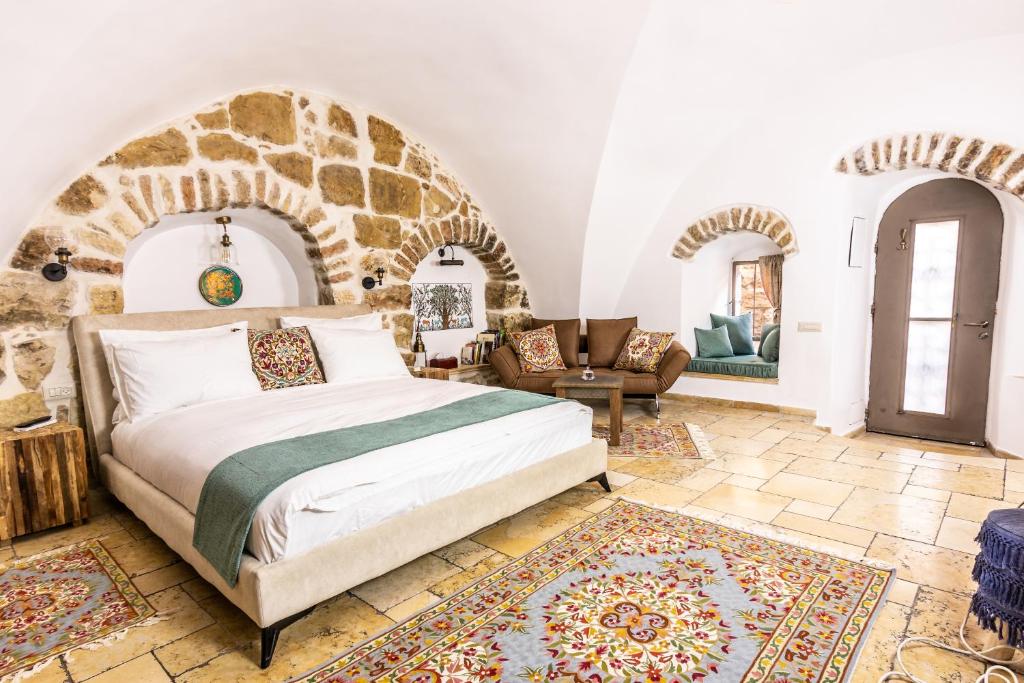 a bedroom with a bed and a stone wall at Flora Valley Boutique Hotel in Jerusalem