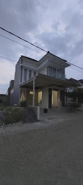 une grande maison blanche au sommet d'une rue dans l'établissement VILLA BAGUS KAYANA H2 DI BATU JAWA TIMUR, à Batu