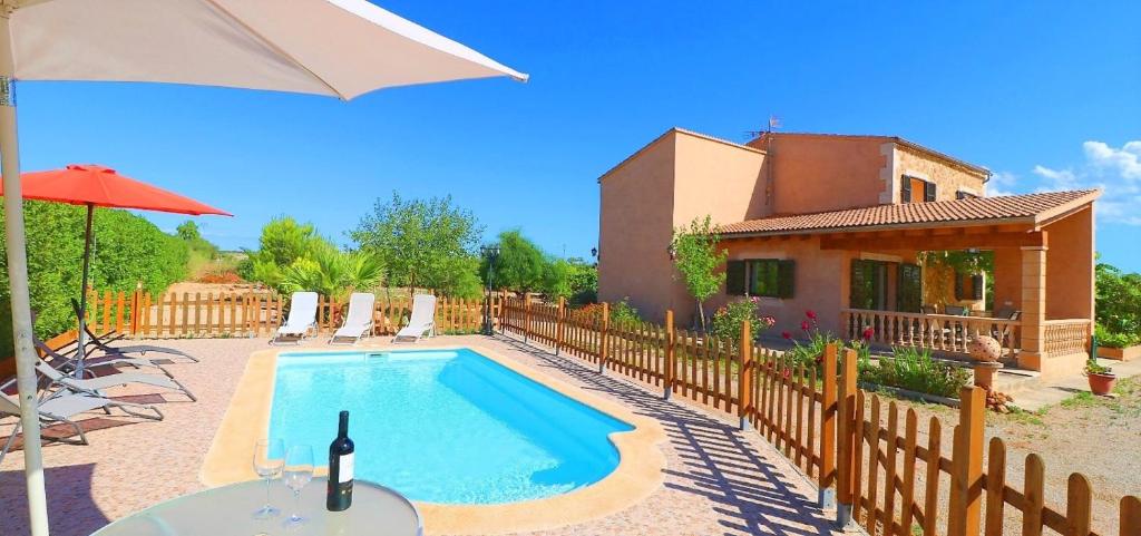 eine Villa mit einem Pool vor einem Haus in der Unterkunft Finca Can Olivaret 419 by Mallorca Charme in Campos