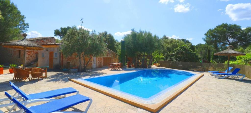 a swimming pool with blue chairs and a house at 411 Finca Sa Costa ETV1976 by Mallorca Charme in Campos