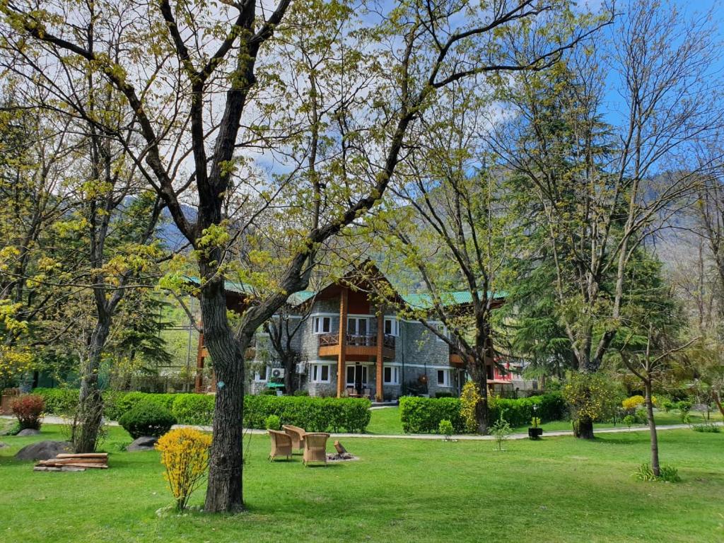 a park with benches in front of a building at Span Resort and Spa in Manāli