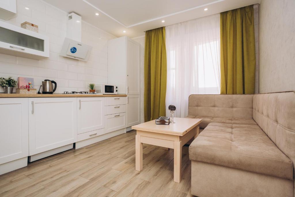 una sala de estar con un sofá y una mesa en Luxe apart-hotel near Lavina New Building 1 floor, en Sumy