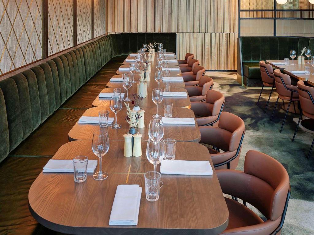 a long table with glasses and napkins on it at Novotel Auckland Airport in Auckland