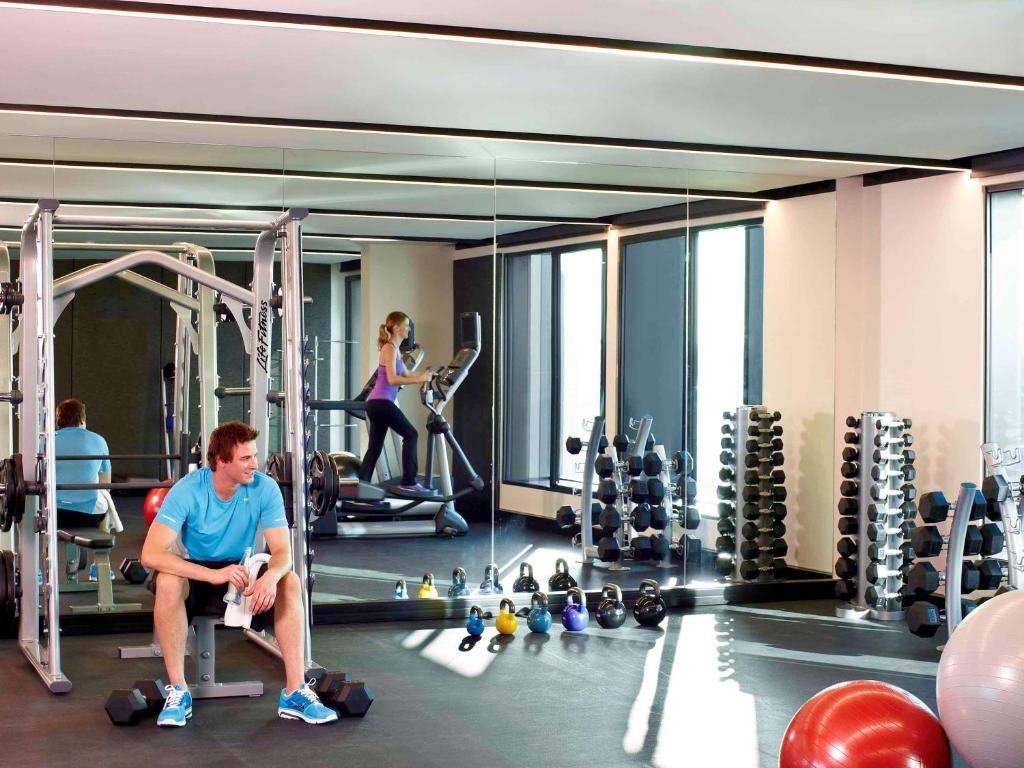 a man sitting on a chair in a gym at Novotel Auckland Airport in Auckland