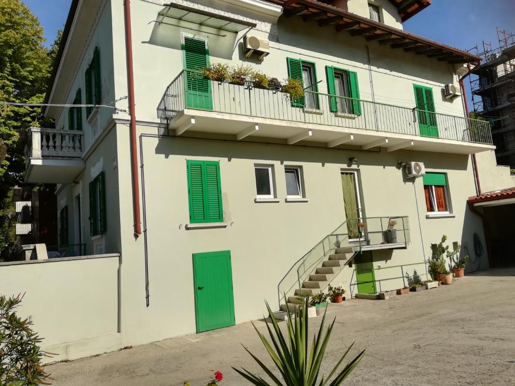 a building with green shutters and a balcony at Gorizia vacanze in Gorizia