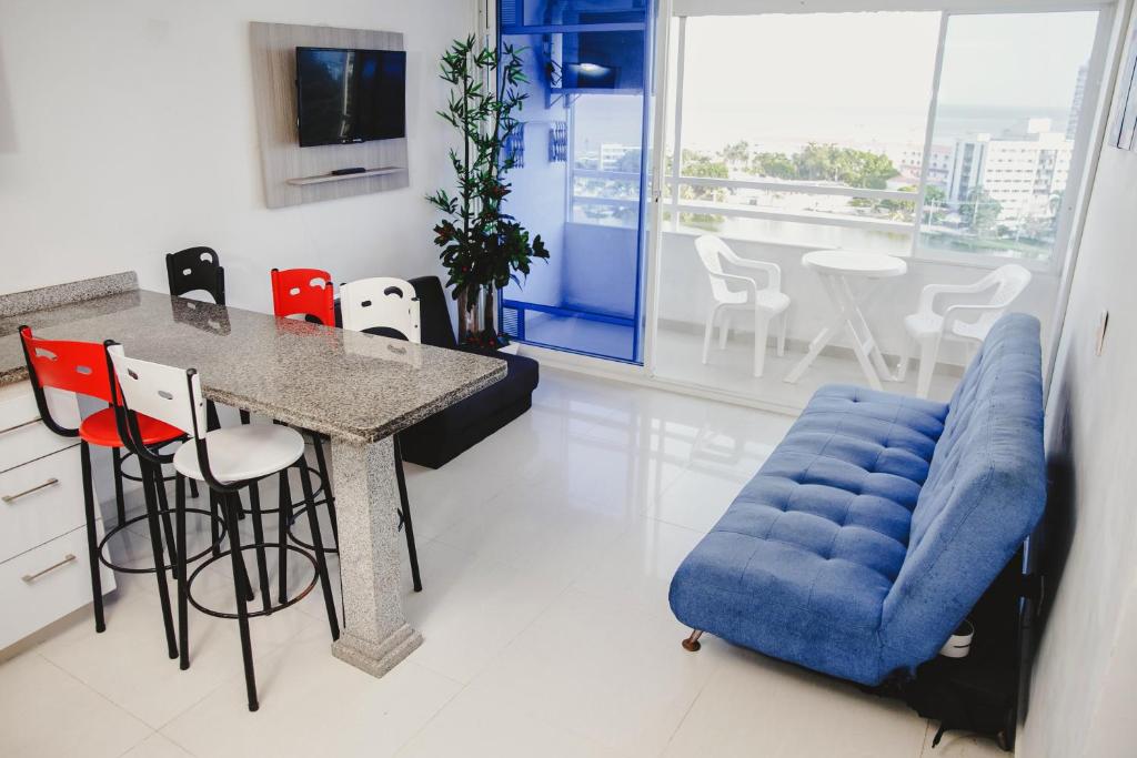 cocina con sofá azul, mesa y sillas en Apartamento Welch, en Cartagena de Indias