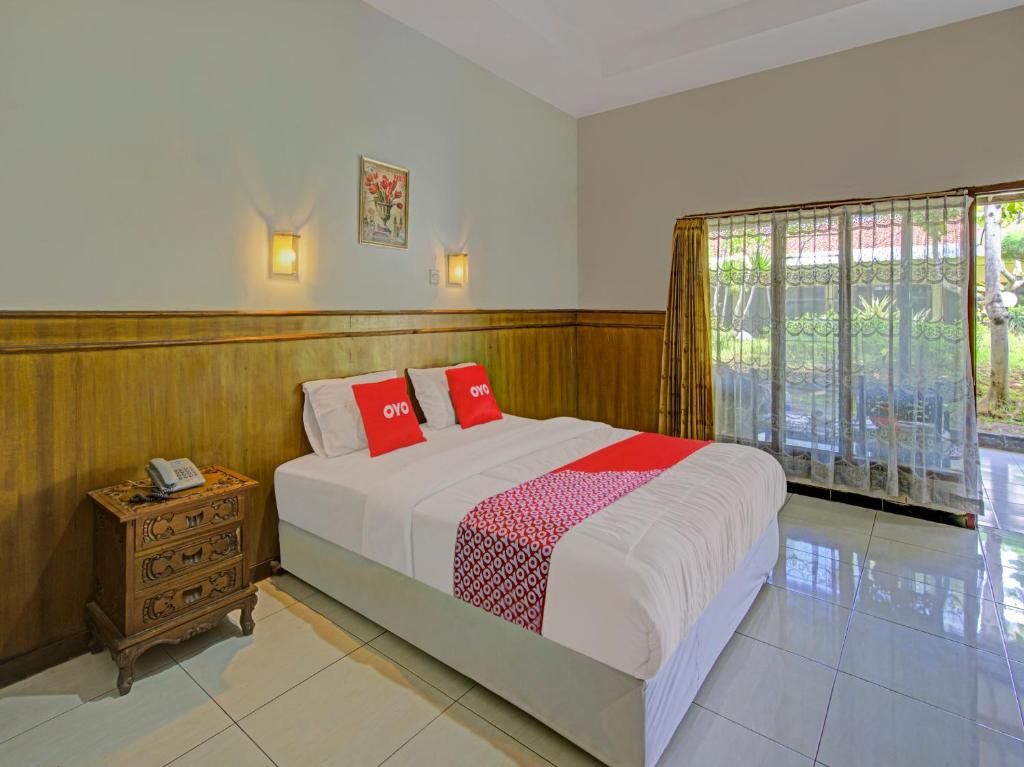 Un dormitorio con una cama con almohadas rojas. en OYO 3934 Hotel Istana, en Pekalongan