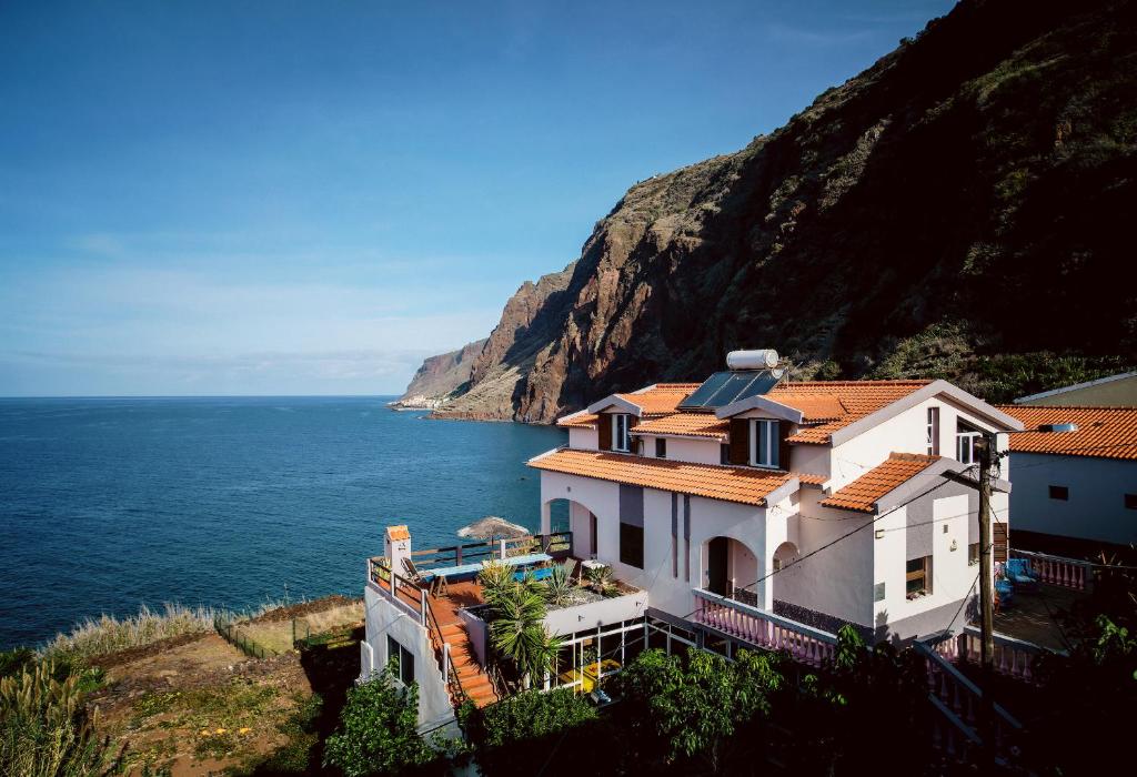a house on a hill next to the ocean at Cecília's House in Jardim do Mar