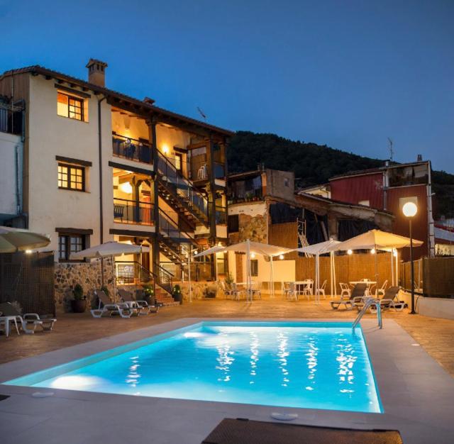 a large swimming pool in front of a building at Natural&Mente Valle del Jerte in El Torno