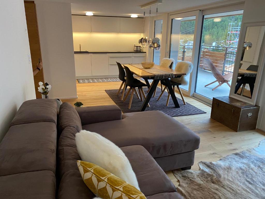 ein Wohnzimmer mit einem braunen Sofa und einem Tisch in der Unterkunft Britannia - Apartment Patagonia in Saas-Fee