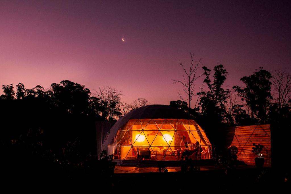 una gran casa en la cúpula con luces por la noche en Domescapes in the Vines en Sidmouth