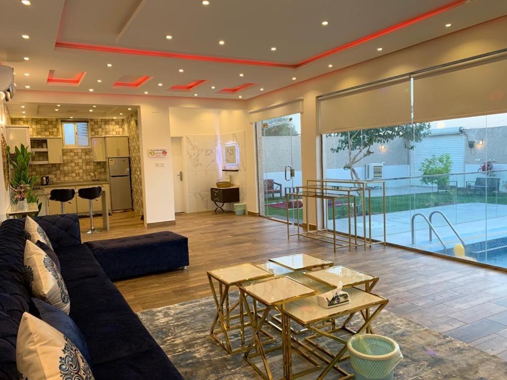 uma sala de estar com um sofá e uma mesa em شاليه الفورسيزونز em Buraydah