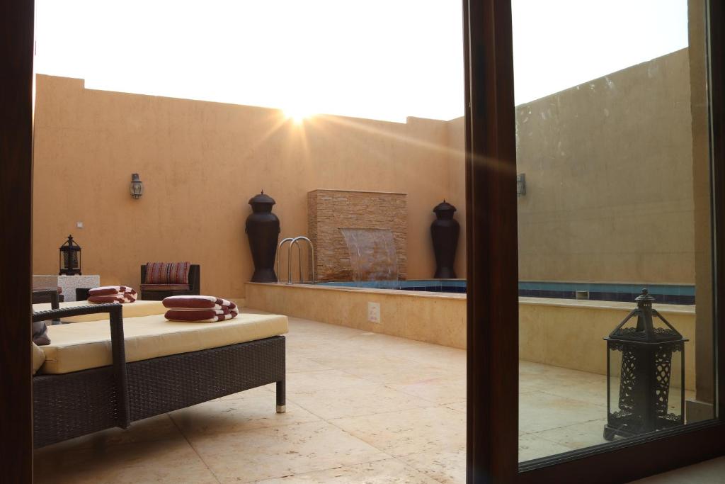 a room with a pool and a bed and a window at Western Hotel - Madinat Zayed in Madīnat Zāyid