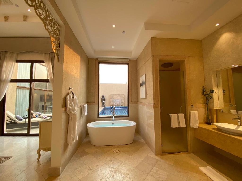 a large bathroom with a tub and a sink at Western Hotel - Madinat Zayed in Madīnat Zāyid