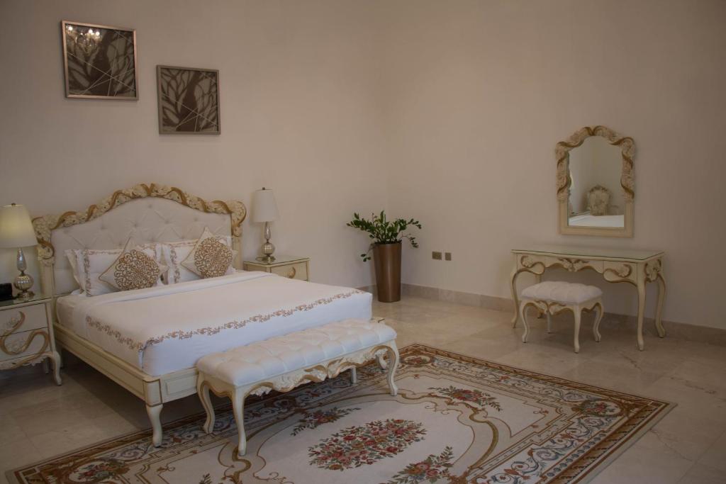a bedroom with a bed and two tables and a mirror at Western Hotel - Madinat Zayed in Madīnat Zāyid