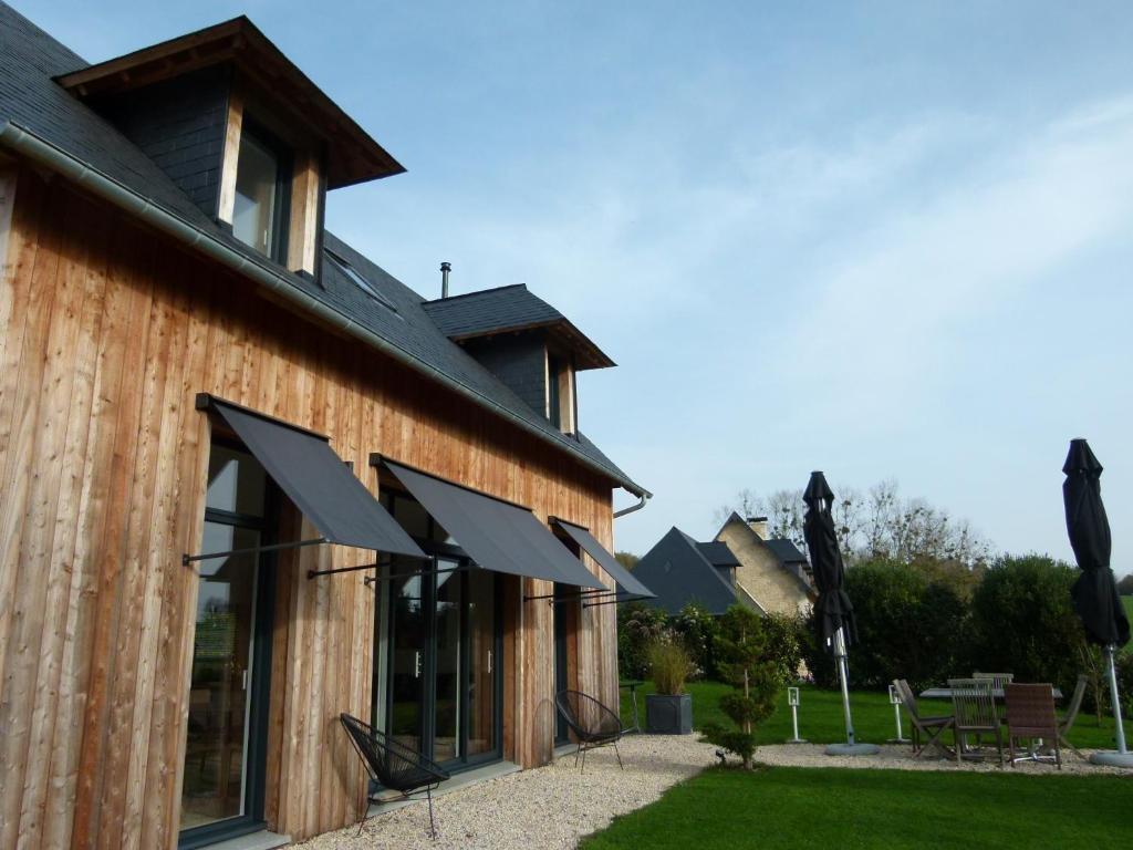 une maison avec des auvents noirs sur son côté dans l'établissement DEAUVILLE 5 min, La Cabane des Princesses, à Bonneville-sur-Touques