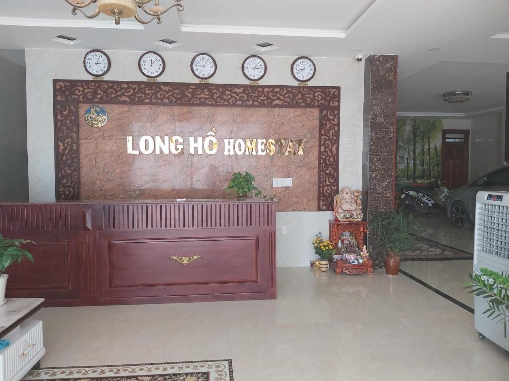 una gran entrada a una larga casa de cerdos con relojes en la pared en Long Hồ Homestay en Xóm Mỹ Ca